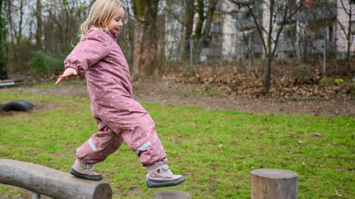 Kind auf Balancier-Element auf dem neuen Kinderspielplatz Wörthersee Straße.