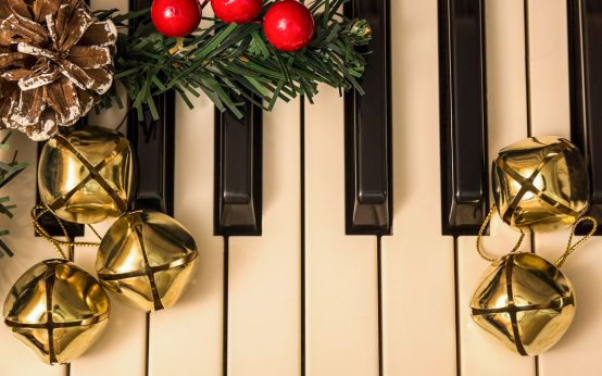 Klaviatur eines Klaviers weihnachtlich dekoriert. Weihanchtssingen