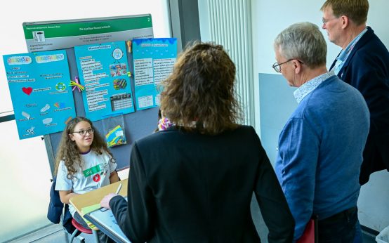 Jugend forscht, die Jury lässt sich die Wasserschlacht ohne Plastik erklären.
