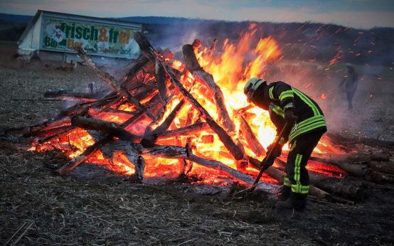 Die Freiwillige Feuerwehr kontrolliert das Osterfeuer am Scholzenhof.