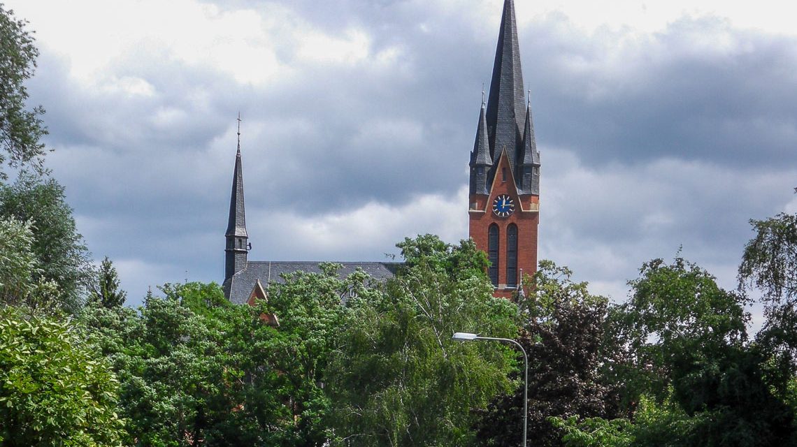 Blick von der Straße Mühlberg jenseits der Wickerbachaue nach Norden auf die evangelische Kirche.