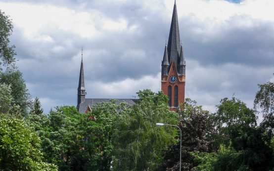 Blick von der Straße Mühlberg jenseits der Wickerbachaue nach Norden auf die evangelische Kirche.