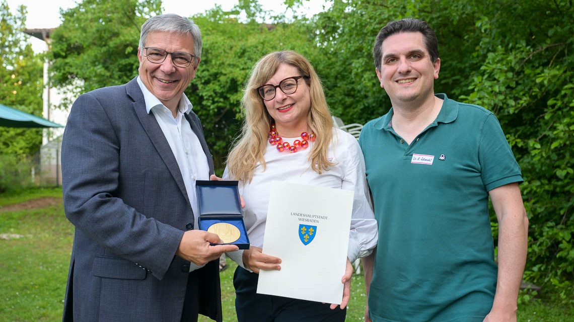 OB Gert-Uwe Mende, Kulturdezernent Dr. Hendrik Schmehl überreichen der Direktorin der vhs Wiesbaden Dr. Stephanie Dreyfürst die Goldene Stadtplakette ©2025 Volker Watschounek