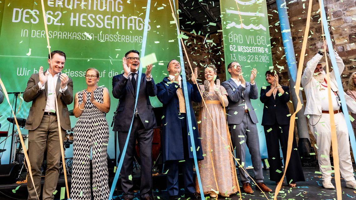 Bürgermeister Sebastian Wysocki, Staatskanzlei-Chef Benedikt Kuhn, Tanja Raab-Rhein, Ministerpräsident Boris Rhein, das Hessentagspaar Matthias Kallmeyer und Ena Kaufmann sowie Landrat Jan Weckler (v. l. n. r.) feiern die Eröffnung des Hessentages 2025 in Bad Vilbel.