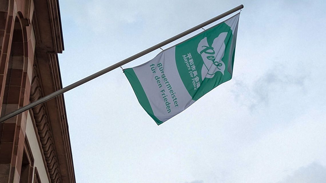 Am Rathaus weht am 8. Juli die Friedensflagge: Wiesbaden zeigt Flagge für nukleare Abrüstung – als Teil des weltweiten Netzwerks Mayors for Peace.