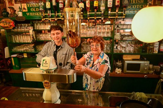 Lukas Schneider zapft ein Guiness und Irmgard Schneider eine Williams Birne.