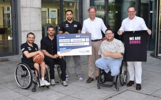 Zwei genossenschaftlich geprägte Unternehmen engagieren sich für eine gemeinsame Sache: Jens Hasselbächer (rechts), Vorstand Kunden & Vertrieb der R+V Versicherung, übergibt gemeinsam mit Peter Marsch (4. von links), Vorstandsmitglied der Wiesbadener Volksbank, einen Scheck über 225.000 Euro an Mirko Korder (5. von links), Geschäftsführer der Rhine River Rhinos. Mit dabei waren auch die Spieler Chris Huber (links) und Mojtaba Kamali (3. von links) sowie Teammanager Marvin Malsy (2. von links)