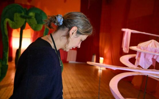 Lola Göller im Inneren einer roten Kirsche, im Innern ihrer Kunstinstallation.