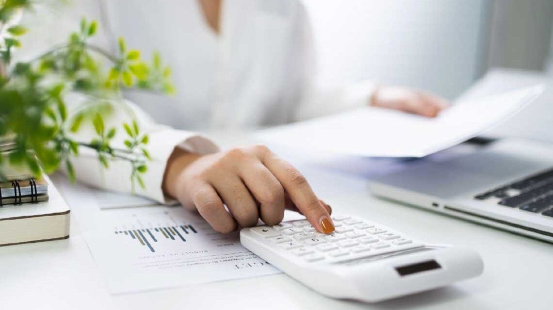 Rechnungswesen, Bilanz prüfen. Nachrechen. Frau tippt zahlen in einen Taschenrechner.