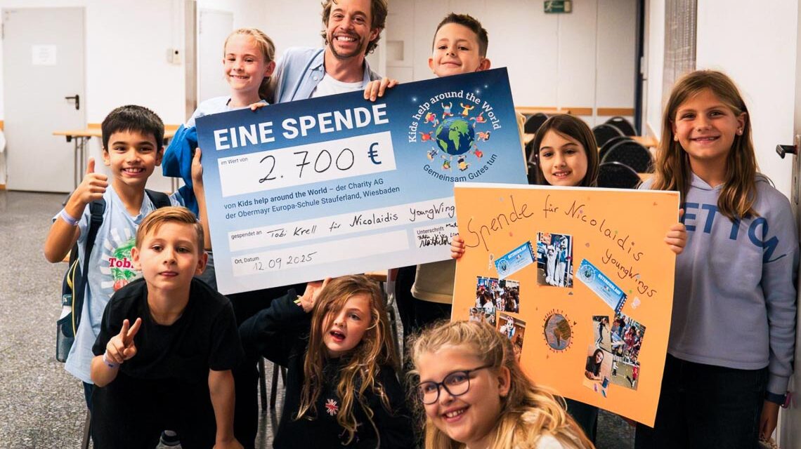 Tobias Krell empfängt den Spendenscheck von der Charity-AG der Obermayr Europaschule – ein Moment voller Stolz und Freude.