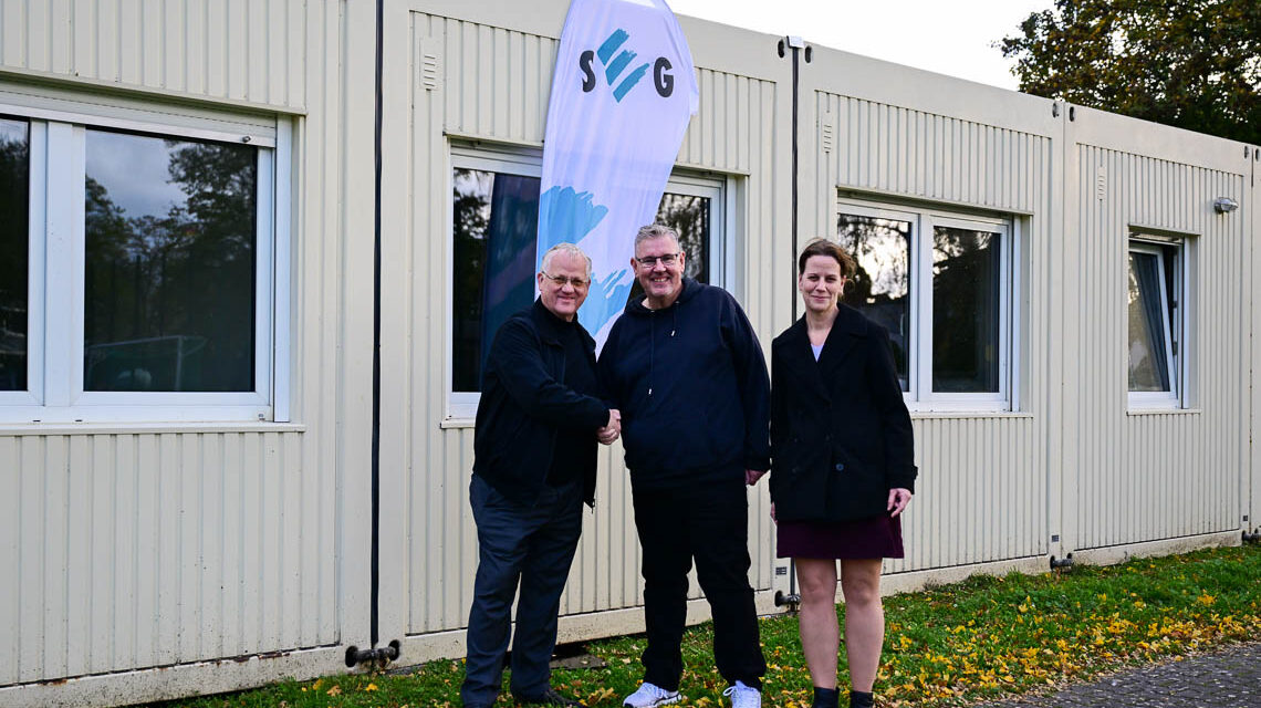 Andreas Guntrum gibt Mike Steinbach Hand und Schlüssel für die Container. Tanja Steinbach freut sich über das neue Vereinsheim für die Fauen-Mannschaften.