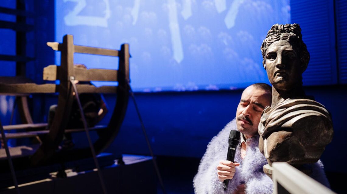 Der Museumswärter blickt auf das verwüstete „Troja“: Zwischen Götterköpfen und Pferdebauch herrscht Chaos – und niemand im Publikum will es gewesen sein