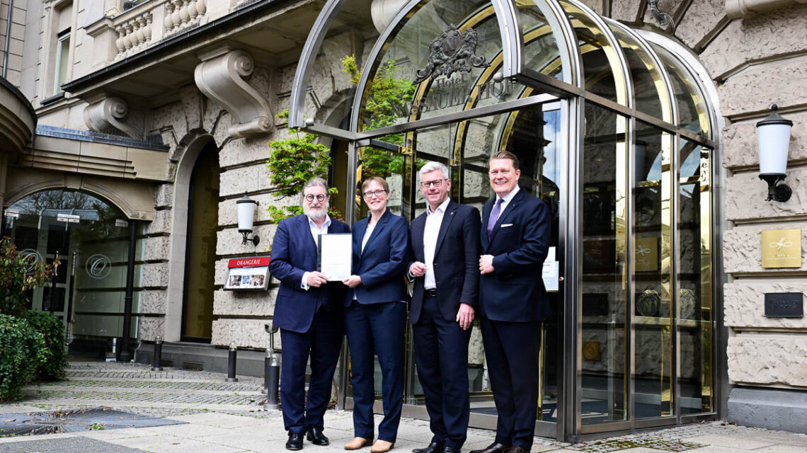 Sandra Matzenauer und Andreas Kowol übergeben Dirk Iserlohe und Jakob Stöhrer die Baugenehigung.