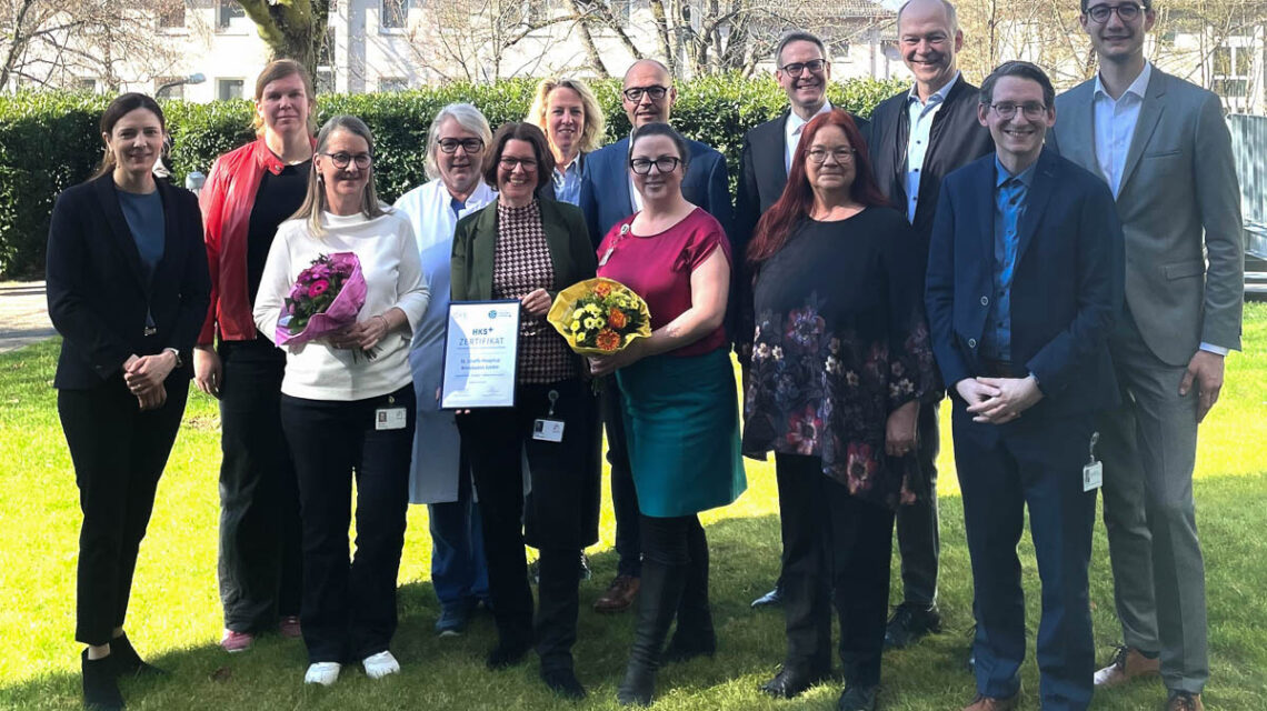 Die JoHo-Hebammen um Uta Krüger und Susanne Vogel (3. und 5. v.li.) feiern die erfolgreiche Zertifizierung des Hebammenkreißsaals+ zusammen mit der erweiterten Geschäftsführung, den ärztlichen Leitern von Frauenklinik und Geburtshilfe sowie externen Gästen, darunter EGW-Geschäftsführerin Angela Tausendpfund (li.), Gesundheitsdezernentin Milena Löbcke (2.v.li.) und Stadtverordnetenvorsteher Dr. Gerhard Obermayr (3. v.li.).