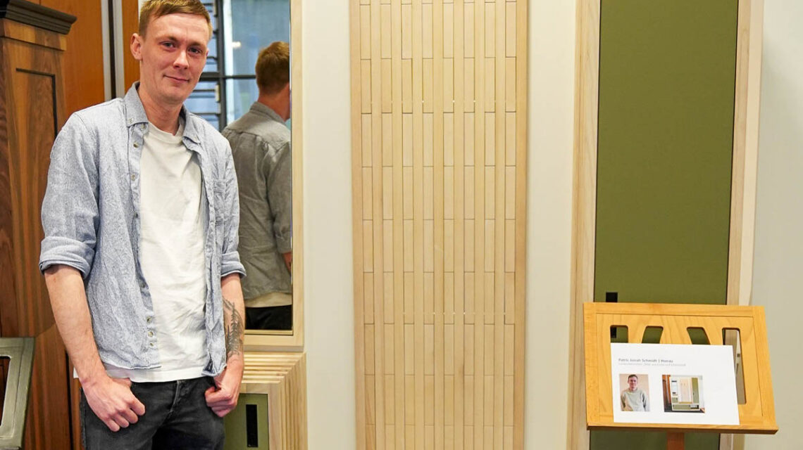 Patric Jonah Schmidt mit seinem Meisterstück, dem Garderobenmöbel „Silva“ aus geölter Esche und Schichtstoff.