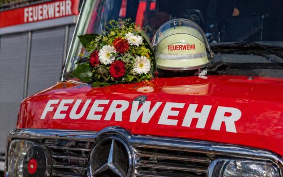 Feuerwehrhelm auf Motorhaube eines Feuerwehrautos.
