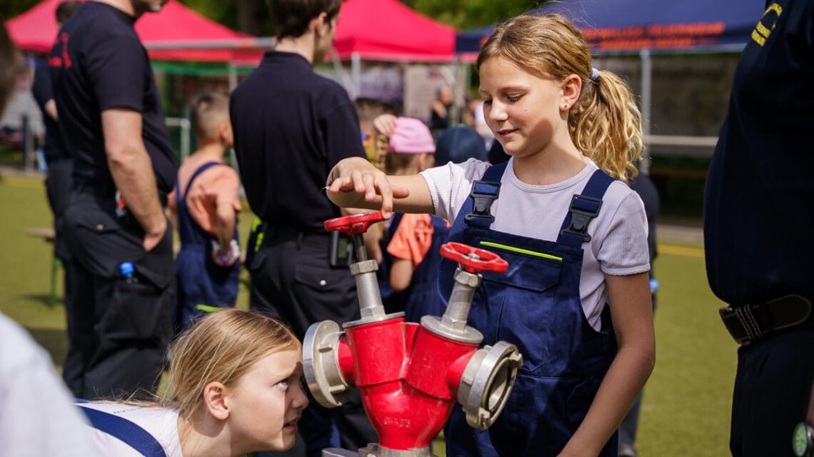 Zwei Mädchen schauen sich einen Verteiler und dessen Funktionsweise genau an.