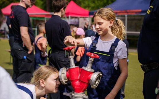 Zwei Mädchen schauen sich einen Verteiler und dessen Funktionsweise genau an.