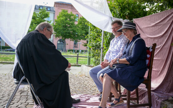 Ein Paar lässt sich auf de Schlossplatz segnen.