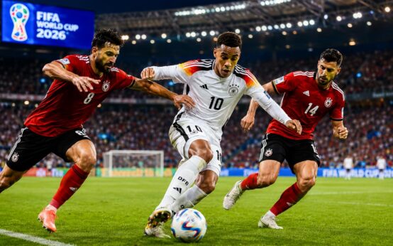 Jamal Musiala setzt sich an der Außenlinie gegen zwei Spieler durch.